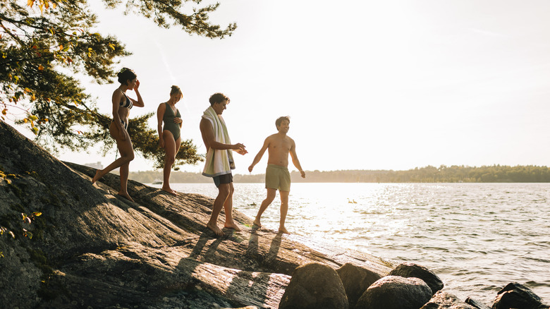 Four young adults on the lakeshore during golden hour.