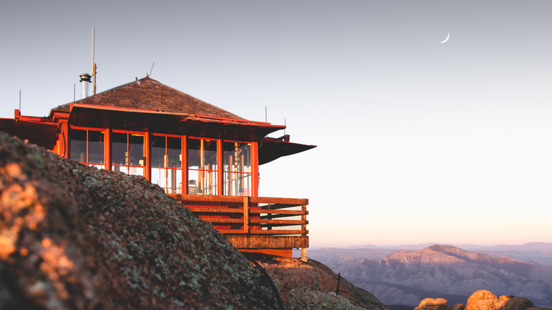 Red fire lookout building at the top of Devil's Head Lookout, bathed in golden light