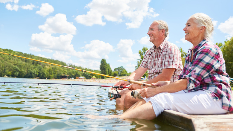 An older adult couple fishing in a lake
