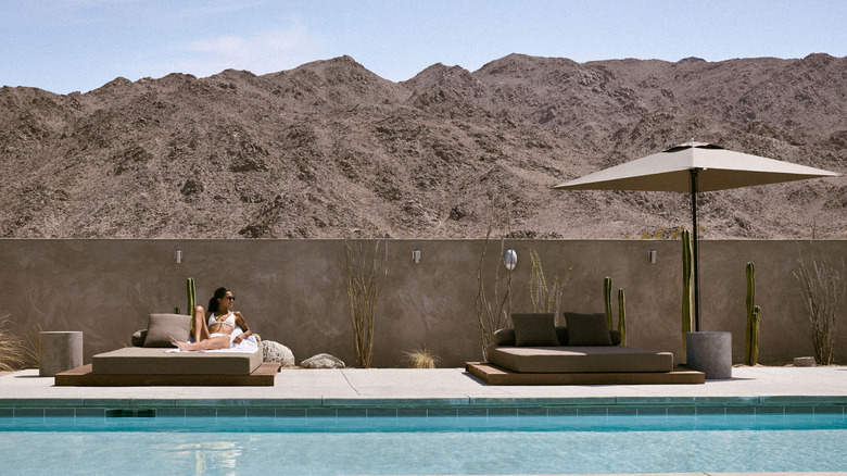 Woman sitting by the Reset hotel pool View Joshua Tree California