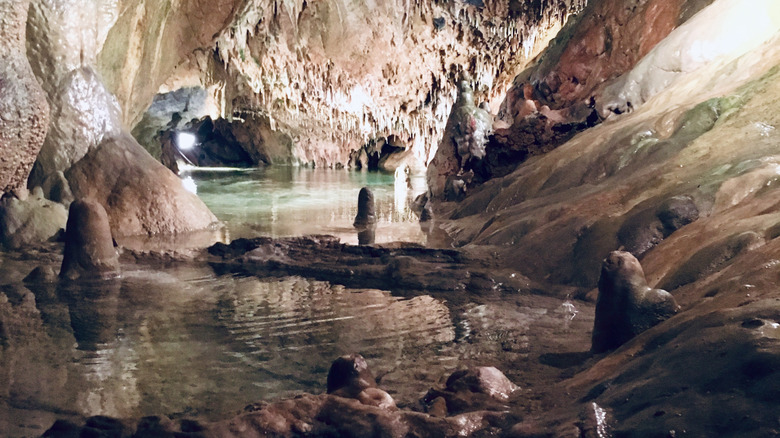 The clear water of crystal lake, illuminated and surrounded by underground rock formations.