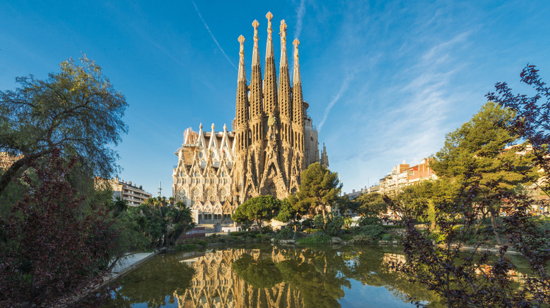 La Sagrada Família with a pond and trees in the foreground