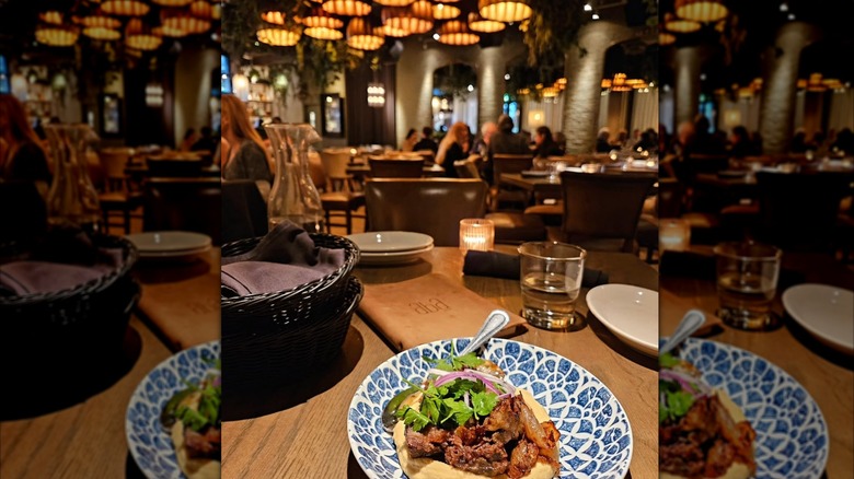 A plate of food on a table with the Aba menu in front of it at the Austin, TX location