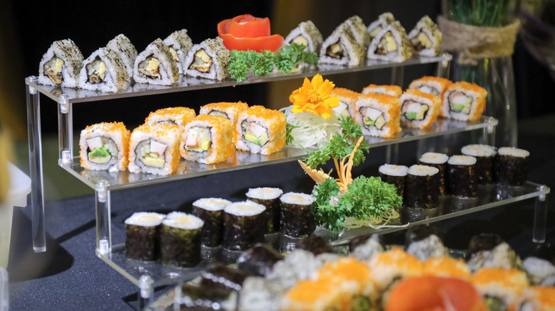 A tiered display of sushi and hand rolls