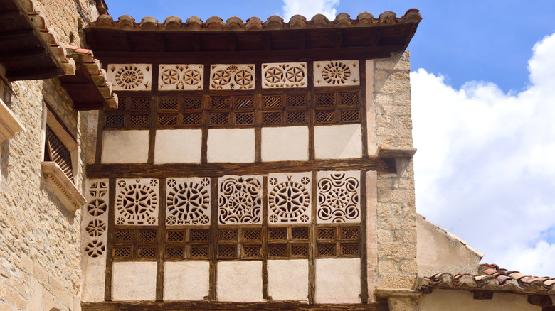 a wall with windows featuring decorative shapes in Mirambel village in Spain