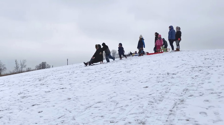 Sledders riding down the snowy Mount Bridgeport in Chicago
