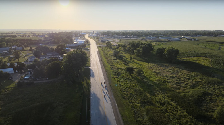aerial view of open road in Gregory, South Dakota, next to green grass and green trees under sunshine