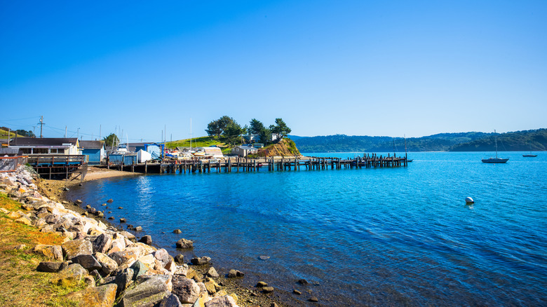 Shoreline and dock leading to blue lake waters