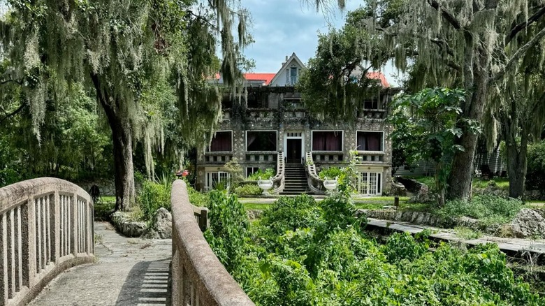 View of Wonder House from concrete bridge with plants and trees