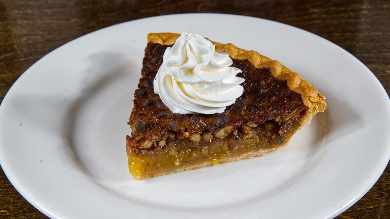 piece of pecan pie with whipped cream on top
