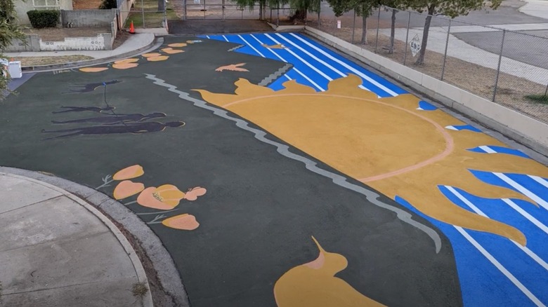 Gold sun with blue stripes and birds painted on playground