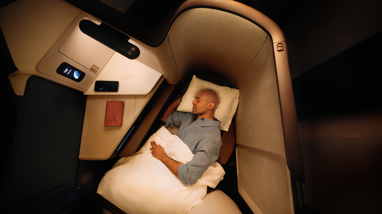 Overhead view of a man sleeping in one of the luxe Aria Suites, Cathay Pacific's business-class seats.