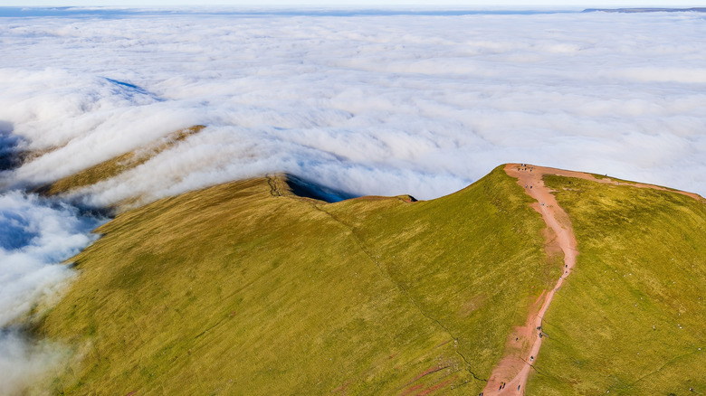 A hiking path crosses a ridge above the clouds in the Brecon Beacons National Park