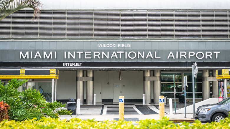 Image of the drop off lane at the front of the Miami International Airport with its name on the overhang out front
