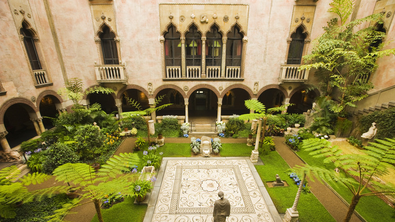 The stunning courtyard with greenery and tile pathways in Isabella Stewart Gardner Museum