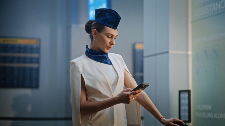 Flight attendant looking at phone