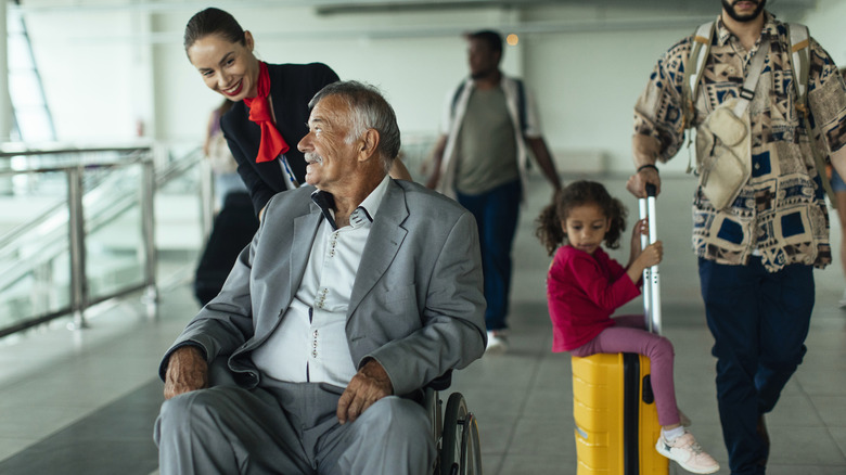 Wheelchair attendant pushing a passenger in the airport