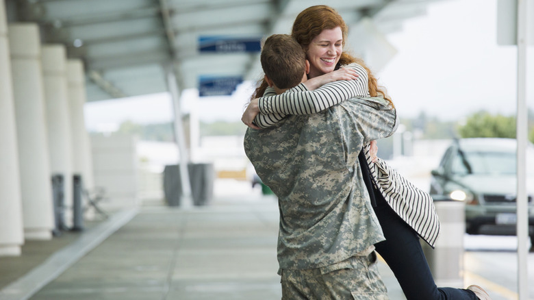 A military member reuniting with his spouse at the airport