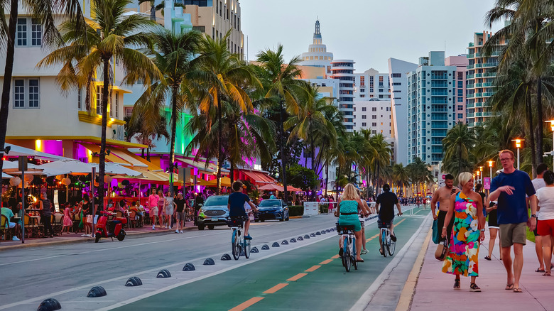 People walk along Ocean Drive on a busy evening in Miami