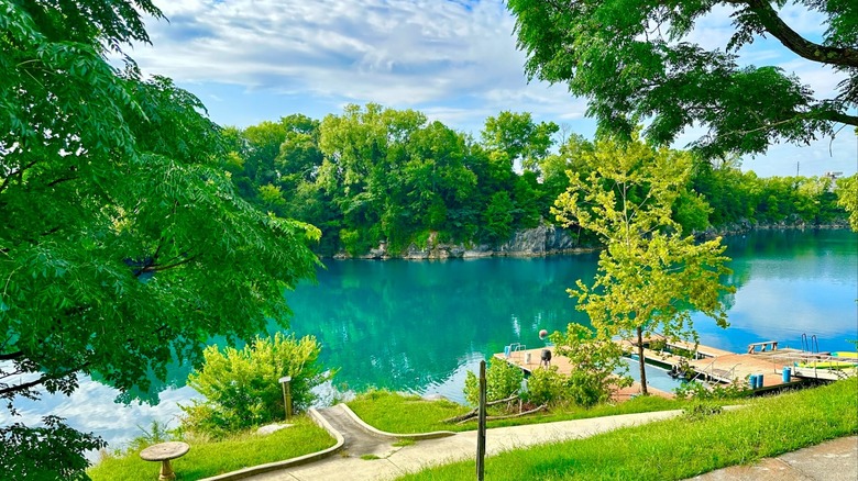 A quarry filled with turquoise water and surrounded by green trees at Blue Water Park, Alabama.