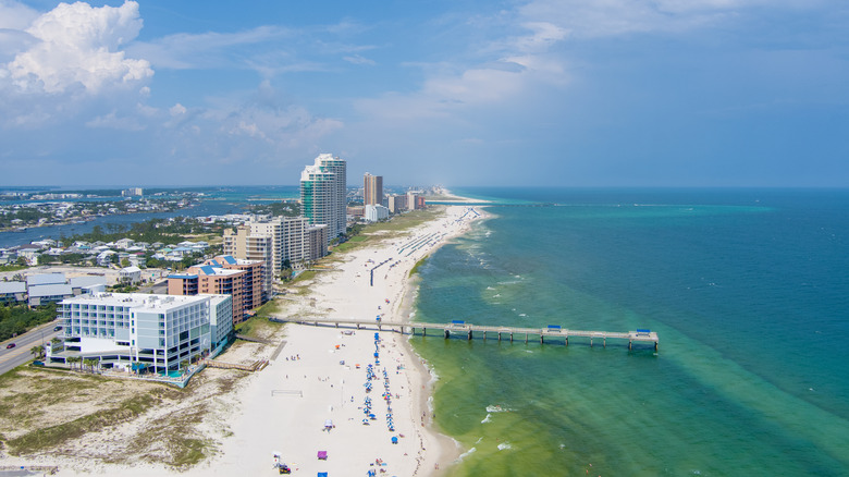 Aerial view of a sugar sand beachfront, turquoise waters, hotels and the pier