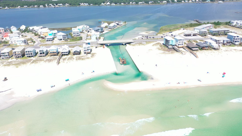 Aerial view of Little Lagoon Pass in Alabama's Gulf Shores with buildings along the shore.
