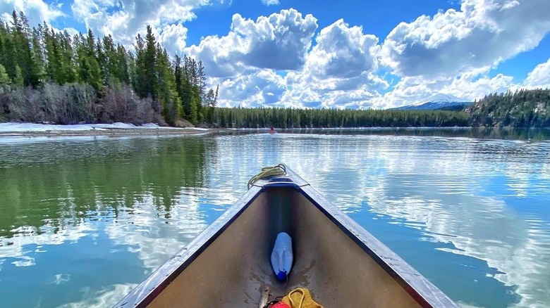Canoe on Yukon River with trees and blue skies