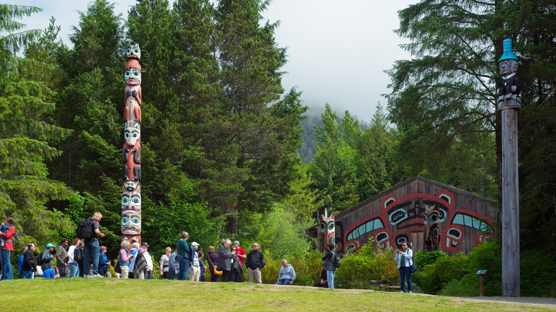 Visitors gather around a totem pole