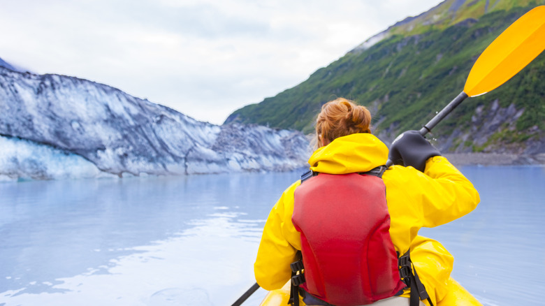 Kayaker paddling near coastal glaciers in Alaska