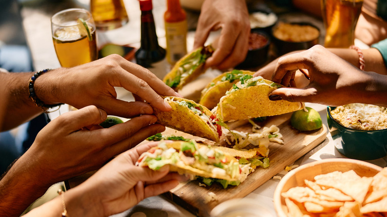 A group of people enjoy some crispy tacos