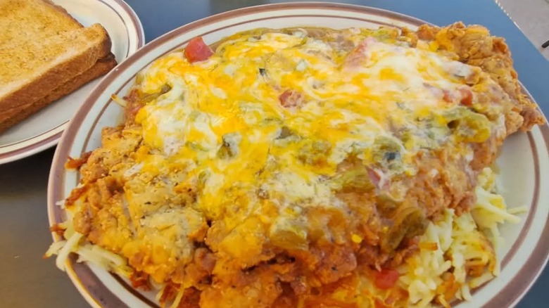 The Vaquero, a chicken fried steak smothered in green chiles and cheese served over hash browns at Vic's Daily Cafe in Albuquerque, New Mexico