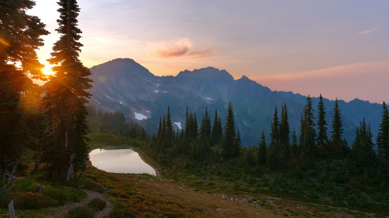 The sun setting over mountains and a small lake on Appleton Pass in Olympic National Park, along the Pacific Northwest Trail (PNT)