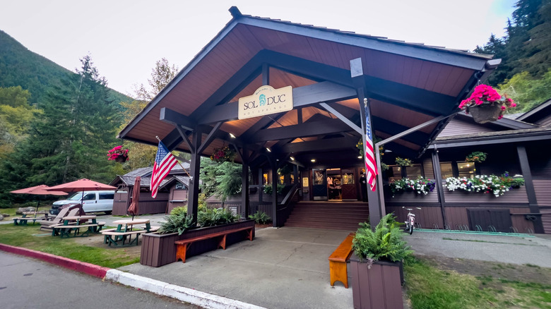 Two American flags hand from the entrance of a lodge-like hot spring resort in Washington.