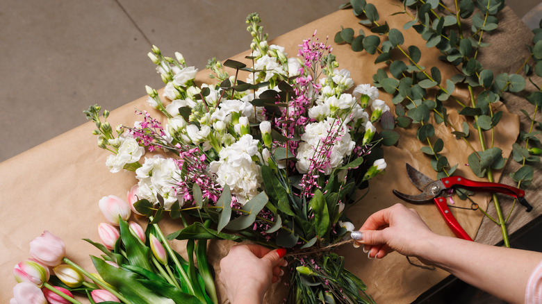 Florist prepares a spring bouquet on a table.