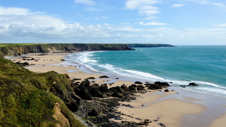 Rocks and reefs poke into the ocean at a beach in Pembrokeshire