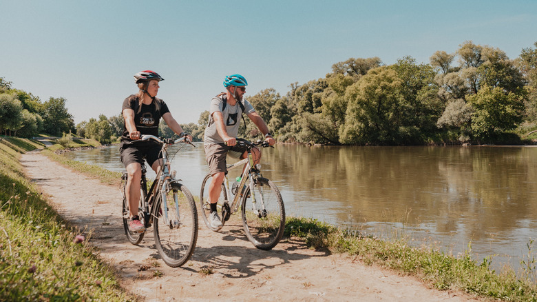 Two cyclists riding a path along the Mura river in Northern Croatia