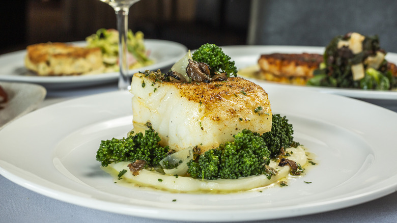 Close-up image of the Chilean sea bass, served with broccolini, potato purée, and pearl onions, one of the crowd-pleasing dishes at Ocean Prime, an upscale surf 'n' turf chain restaurant