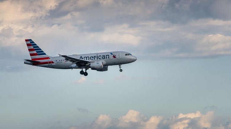An American Airlines flight in a blue sky with clouds