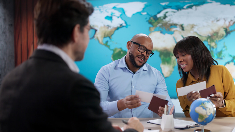 Couple reviewing plane tickets with a travel agent