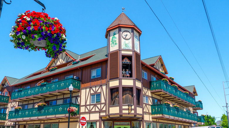 Alpine architecture building, with glockenspiel in the center, hanging potted flowers in the foreground