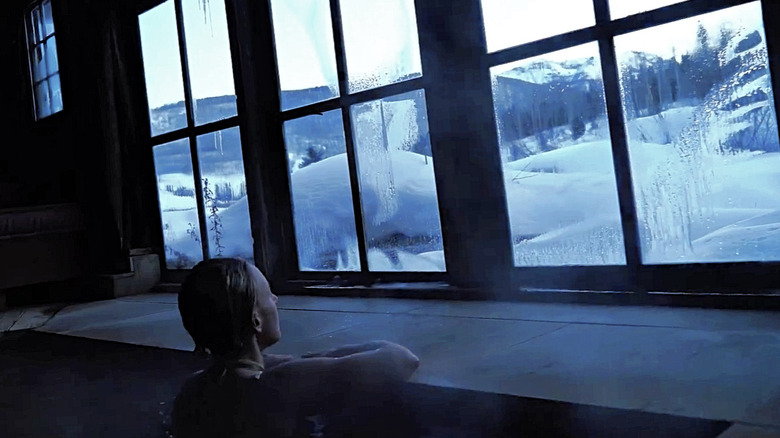 A woman looking out the bathhouse window in winter at Dunton Hot Springs
