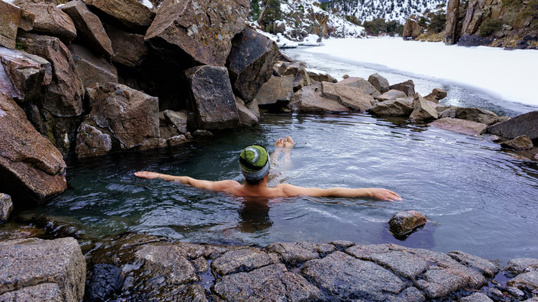 A man enjoying a relaxing soak in winter along the Colorado River.