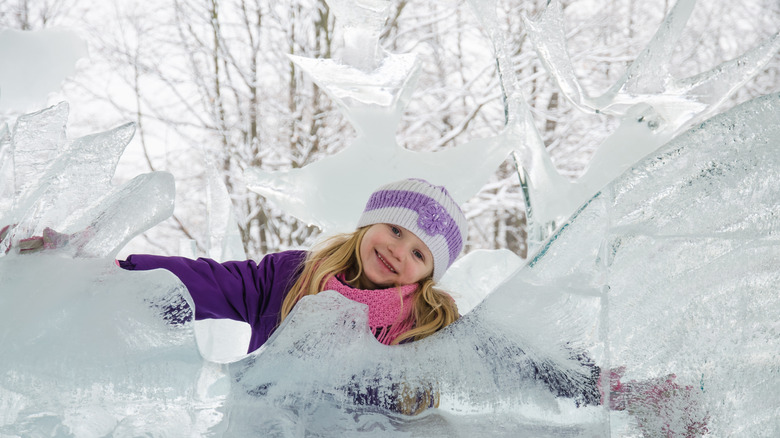 A girl standing next to an ice sculpture