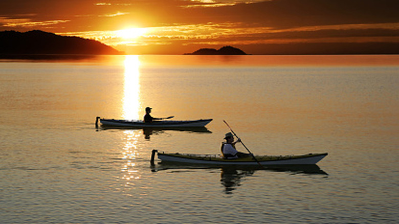 Father and son kayaking on serene lake at sunset, square frame