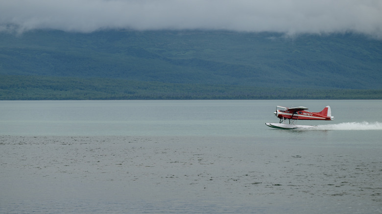 Seaplane landing on the remote surface of Tustumena Lake, Alaska