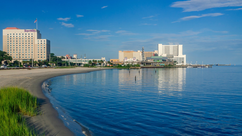 White sands and calm waters on Biloxi Beach with buildings on the shore