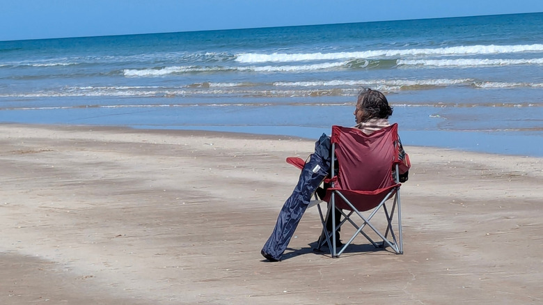 A person staring at the sand on a beach at South Padre Island