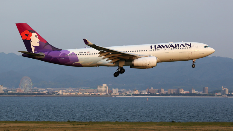 An Airbus A330-200 aircraft from Hawaiian Airlines' fleet approaching Osaka Kansai Airport in Japan.