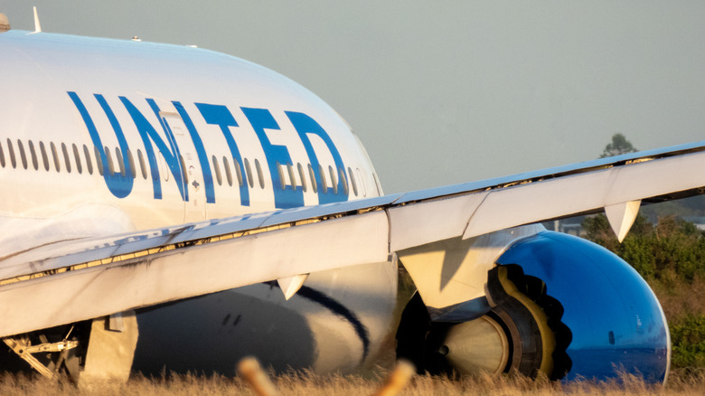 A Boeing B787-9 aircraft from United Airlines' fleet taxiing along a runway at Sydney Kingsford Smith Airport in Australia on a bright day.