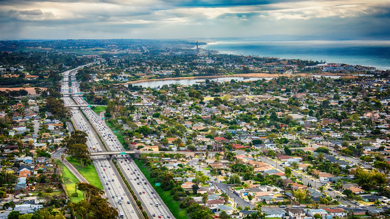 Aerial view as cars drive along Interstate 5 through California with Pacific Ocean on west